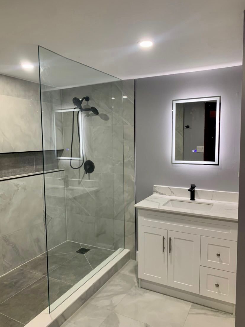 walk in shower with white vanity and LED vanity mirror