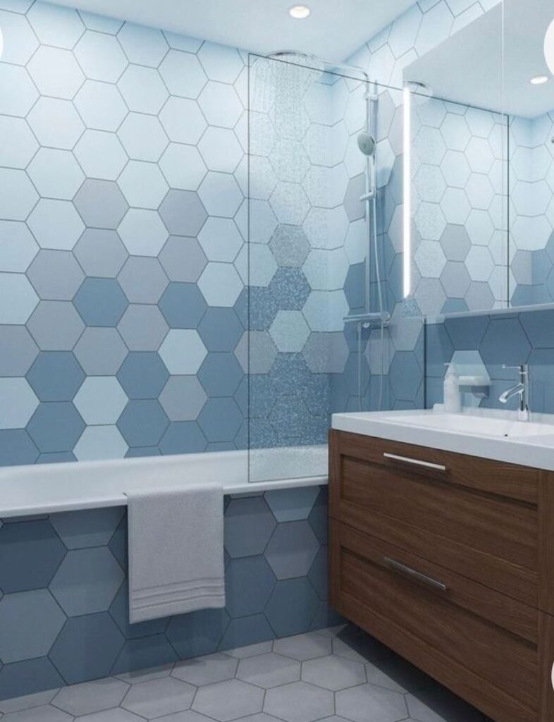 Bathtub with blue hexagon tile and wood vanity