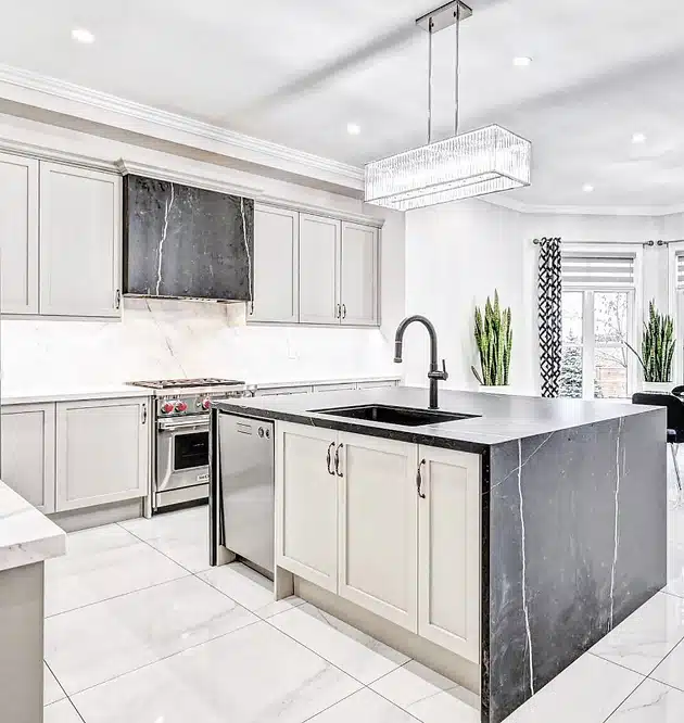 a kitchen with marble counter tops and white cabinets