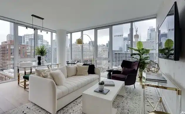 a living room filled with furniture and large windows