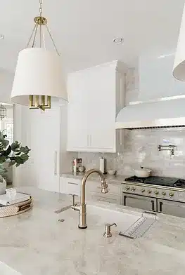 a kitchen with marble counter tops and white cabinets