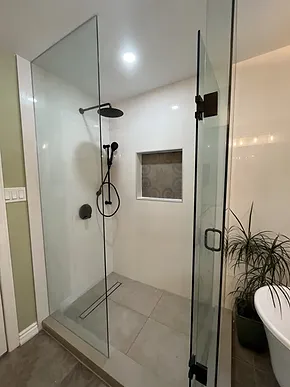 a bathroom with a walk in shower next to a bathtub