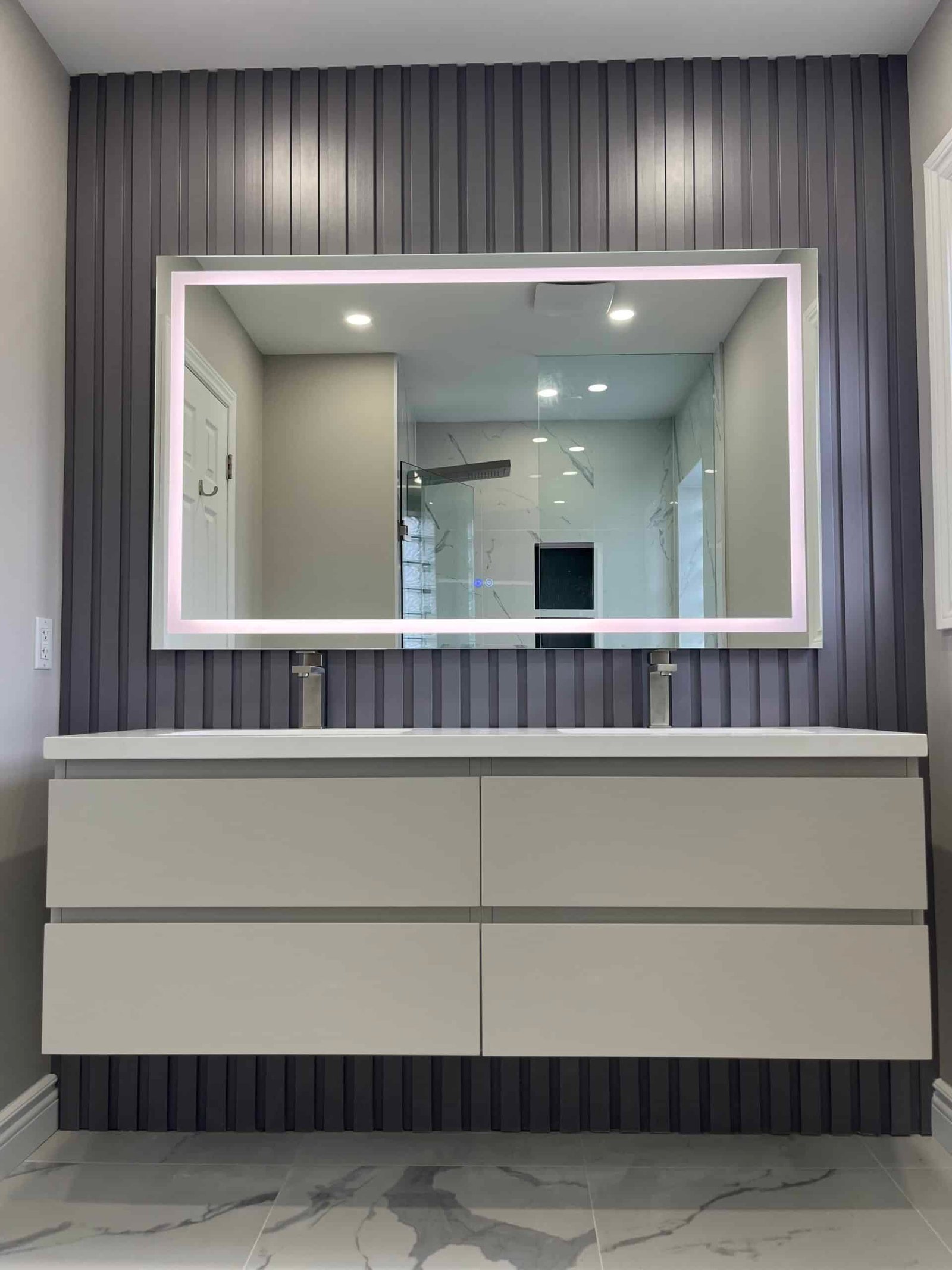 Custom grey floating vanity with LED mirror and decorative wall panels