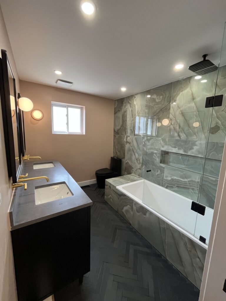 Luxurious bathroom with herringbone tiles and a custom glass shower