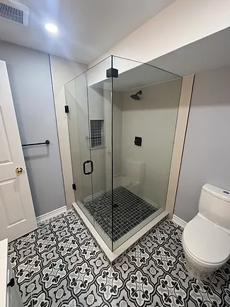a white toilet sitting next to a walk in shower