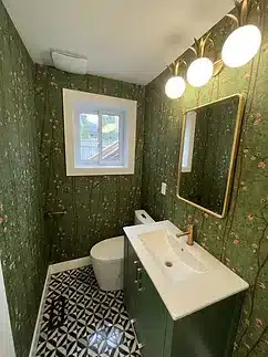 a bathroom with a toilet, sink, and mirror