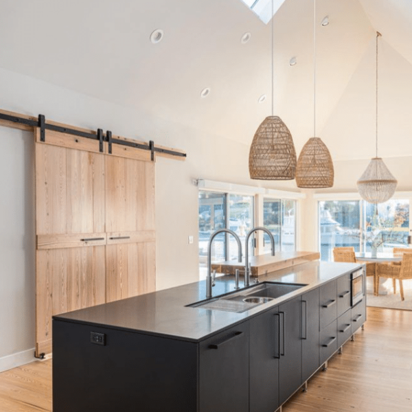 Contemporary black kitchen featuring a large island and pendant lighting