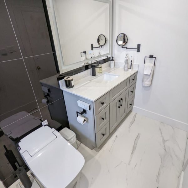 custom vanity with smart toilet and black vanity wall tiles