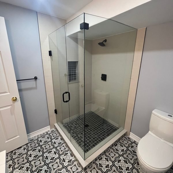 Glass walk-in shower with patterned floor tile