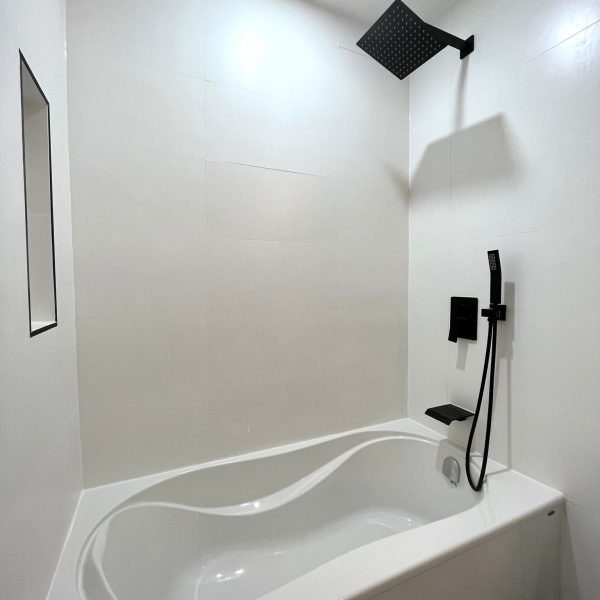 White alcove bathtub with black shower fixtures