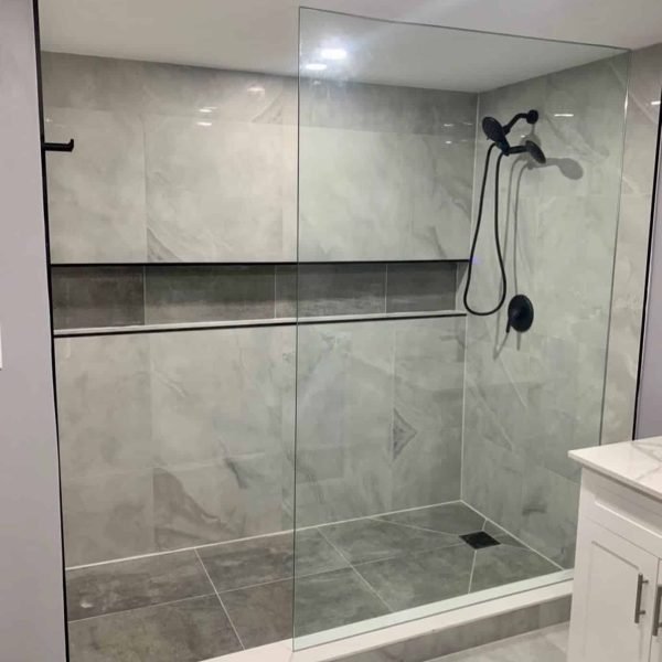 Walk-in shower with grey tile, long niche and glass panel