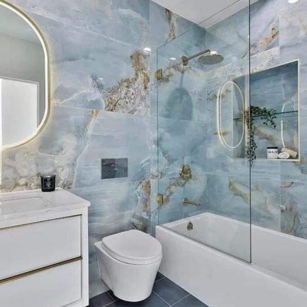 bathtub shower whit blue porcelain tiles and wall mount toilet