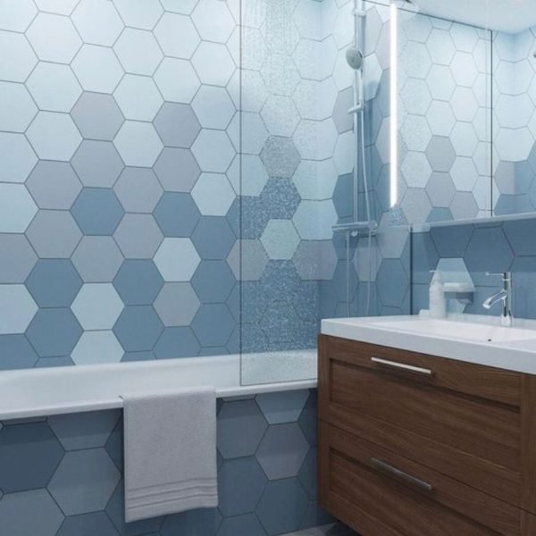 Bathtub with blue hexagon tile and wood vanity