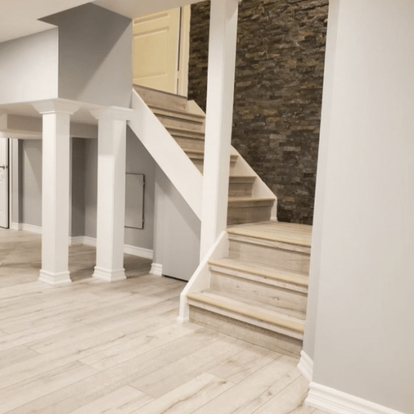 Functional basement remodel featuring a home gym with exercise equipment, mirrored walls, and a durable rubber floor for workouts.