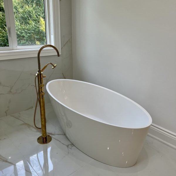 Free standing bathtub with gold free standing faucet